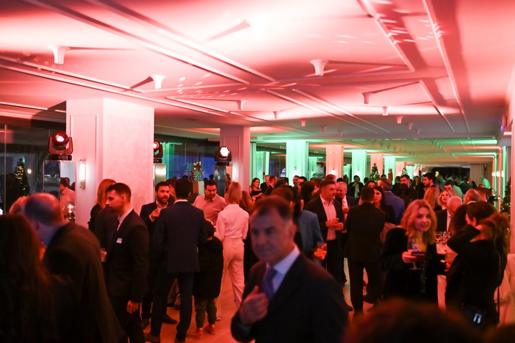 Guests mingling at an end-of-year corporate celebration with colorful event lighting